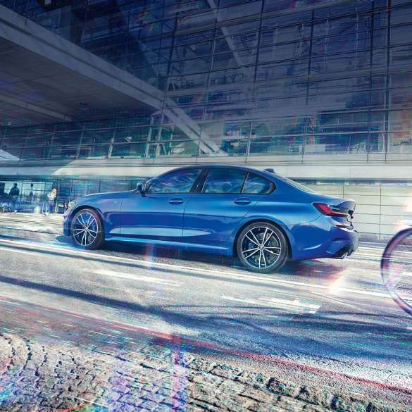 BMW 3 Series, side view. Still shot of the BMW 3 Series from the side on the day in front of a glass building.