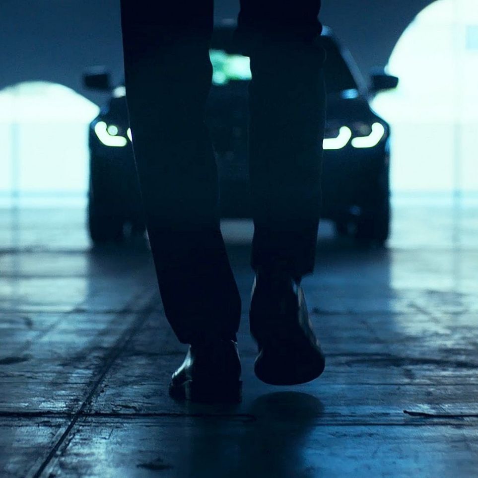 BMW 3 Series, Front. View from behind of walking man in front of the BMW 3 Series on asphalt.