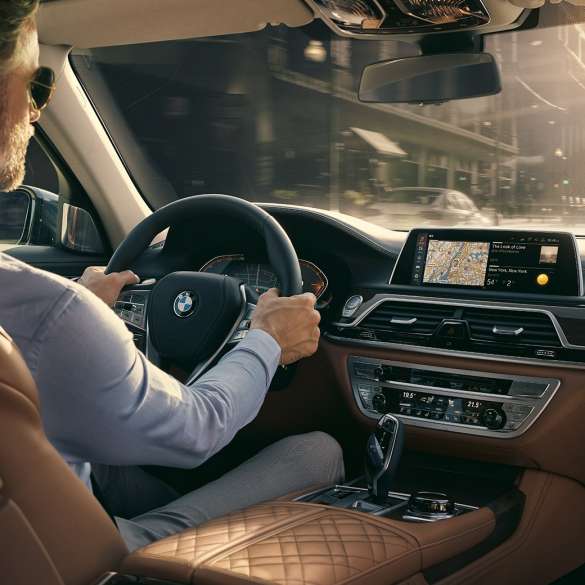 BMW 7 Series Sedan Connectivity features BMW 7 Series Sedan: man sits in BMW and uses Connectivity features