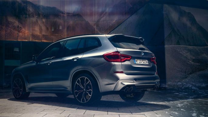 BMW X3 M, lateral rear view. BMW X3 M in Donington Grey metallic, exterior, lateral rear view with two people in the foreground.