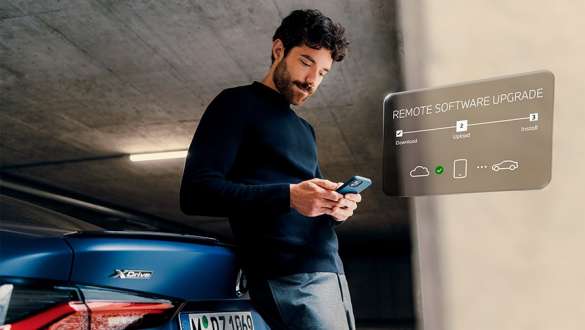 Remote Software Upgrade BMW ConnectedDrive Upgrades BMW ConnectedDrive Upgrades Remote Software Upgrade man with smartphone