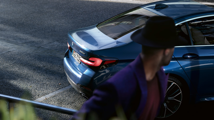 BMW 5 Series Sedan (G30), Phytonic Blue metallic BMW 5 Series Sedan (G30), Phytonic Blue metallic, on parking deck with person in the foreground