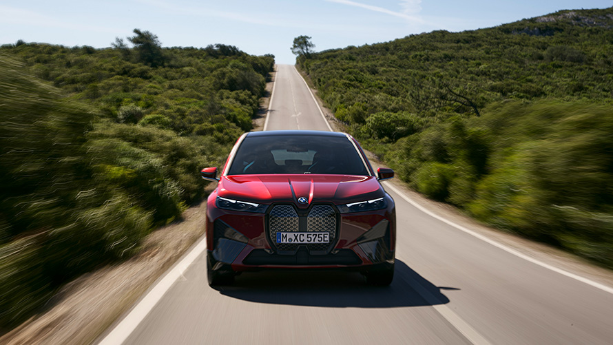 BMW iX i20 electric SUV BMW iX xDrive40 range BMW iX i20 2021 electric SUV BMW iX xDrive40 Aventurin Red driving on a street range