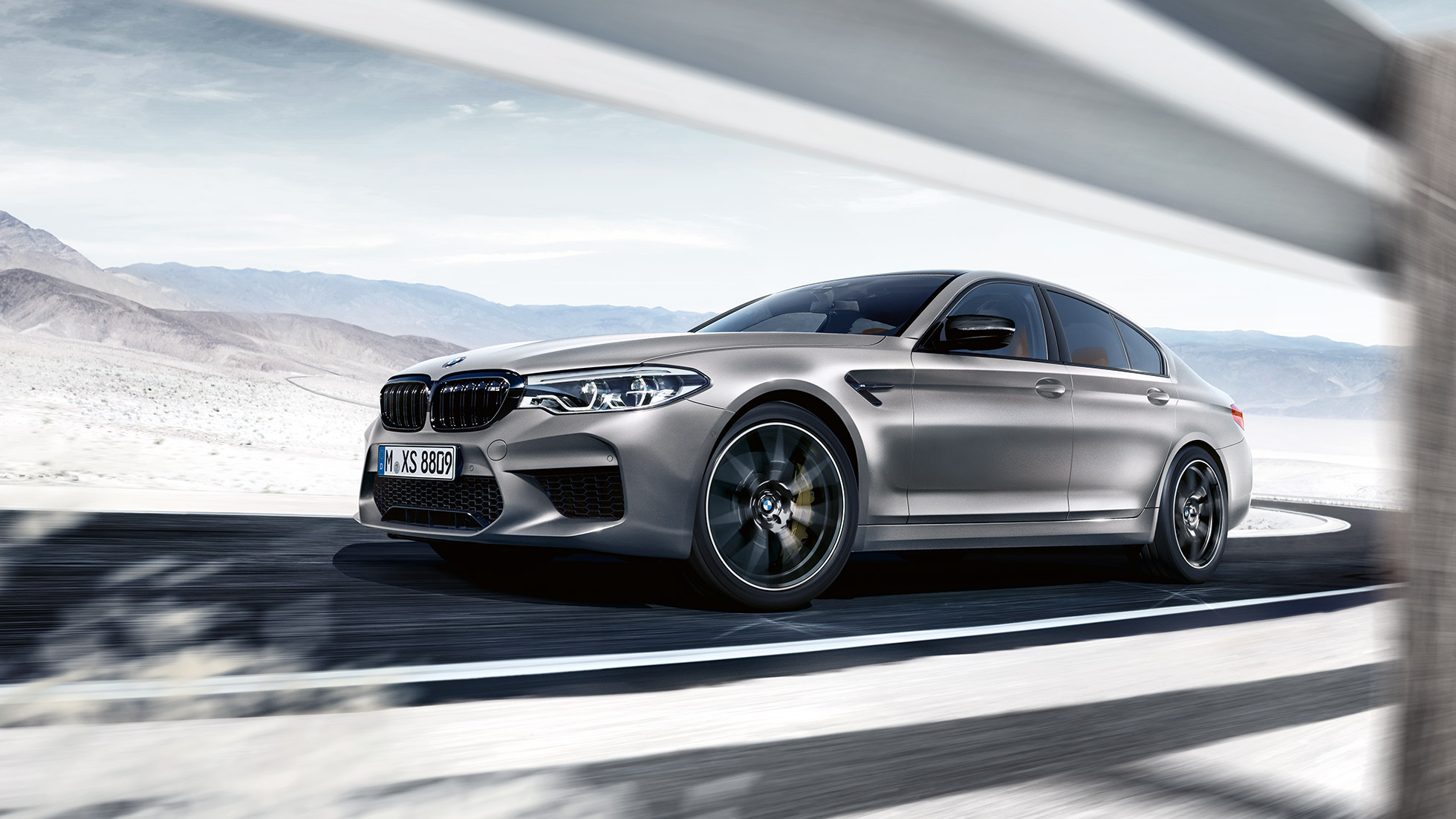 M xDrive. BMW M5 Competition three-quarter front shot while driving.