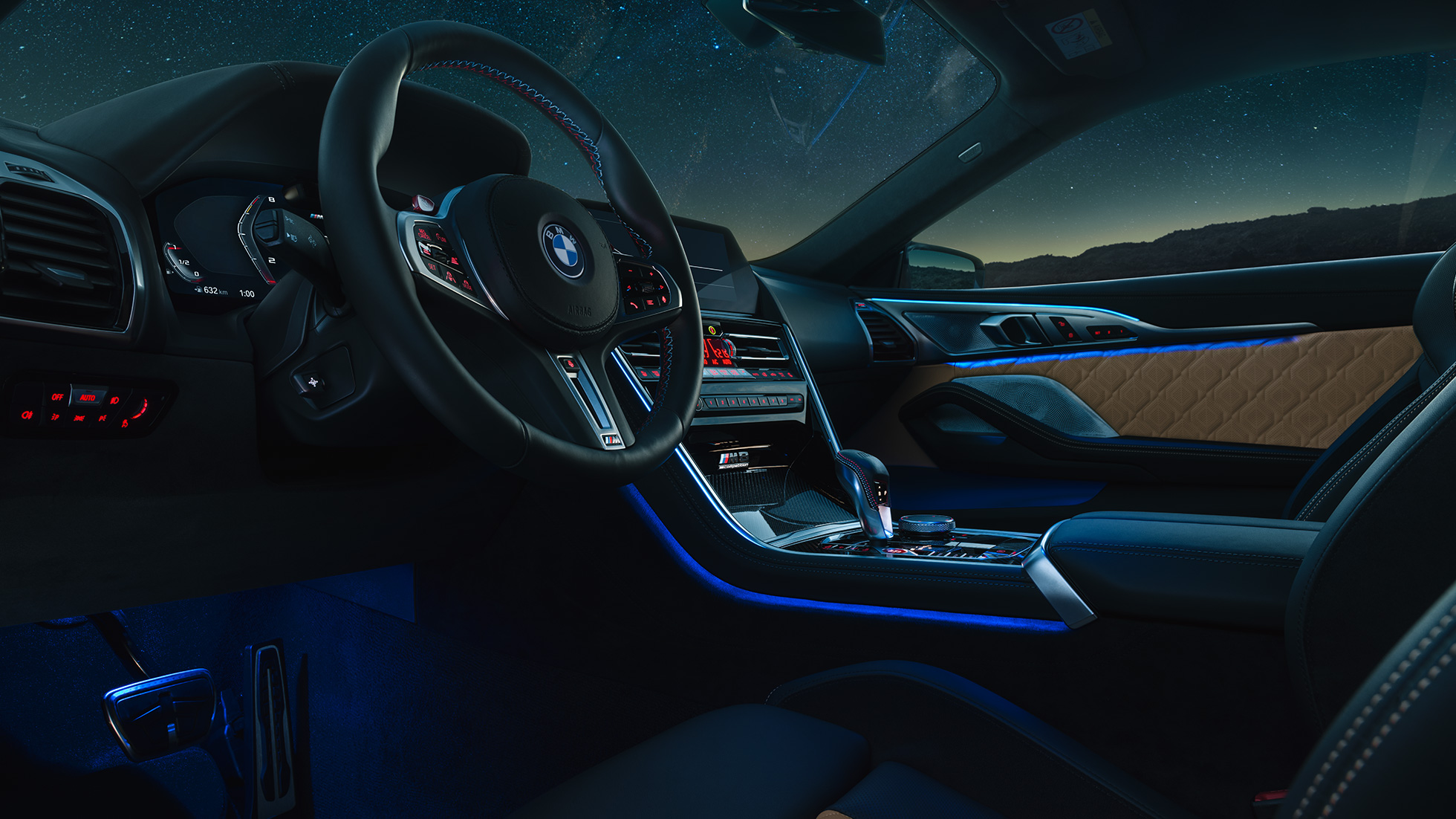 BMW M8 Coupé, cockpit. BMW M8 Coupé, cockpit at night with M leather steering wheel and blue ambient light.
