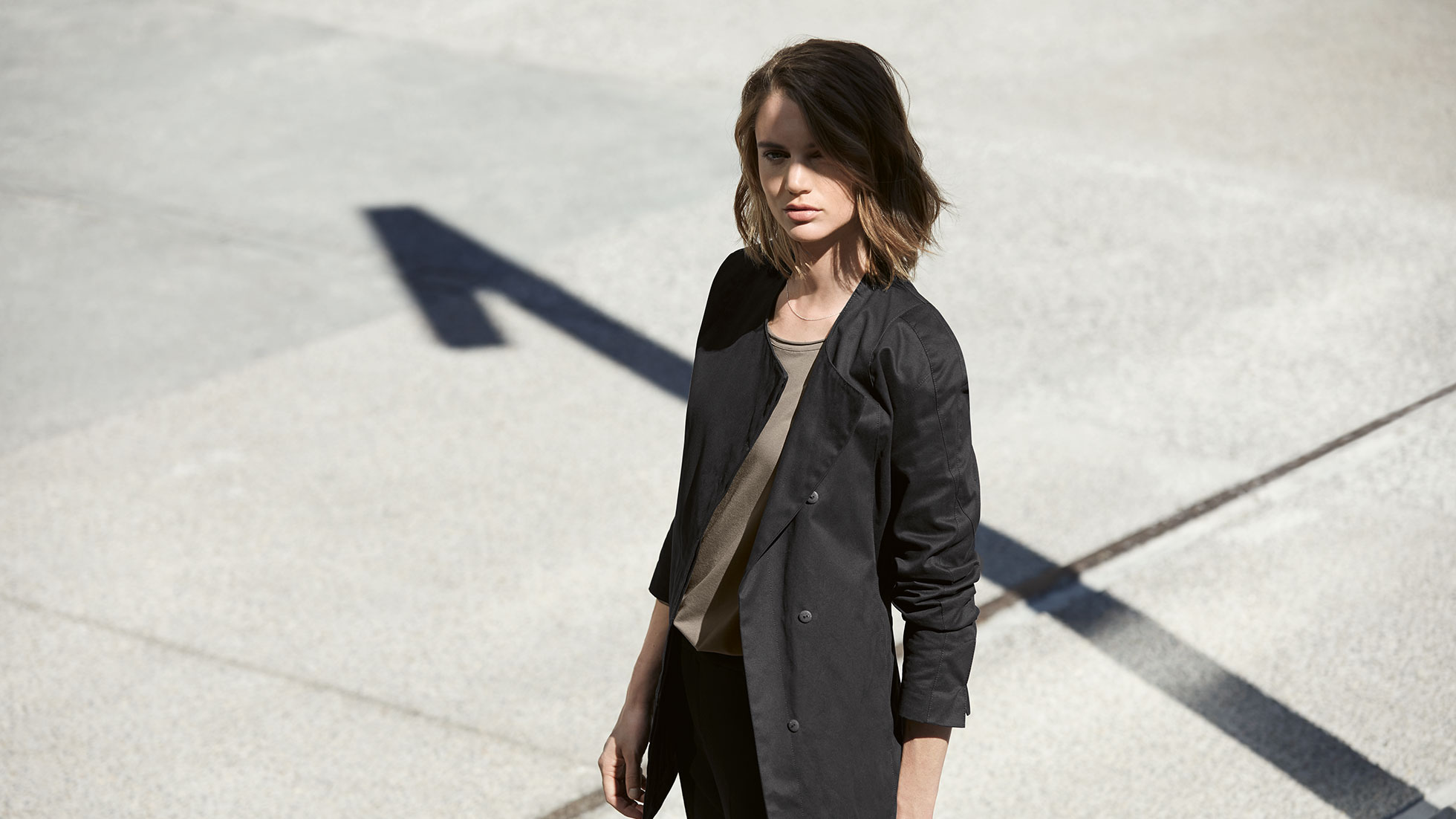 In a BMW i Cardigan for women, you face the future in perfect style. A young woman wearing a BMW i Cardigan for women looks towards the viewer.