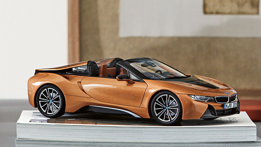 BMW Miniatures. A miniature BMW i8 Roadster sits decoratively on a pile of magazines.
