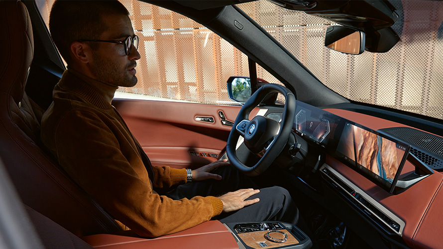 Man in the BMW iX I20 interior view through the passenger window