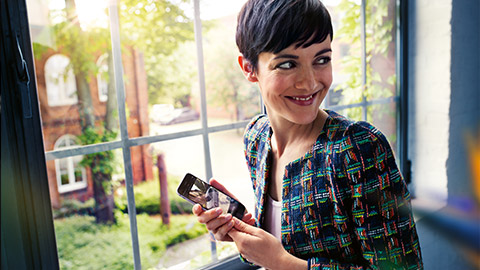 BMW ConnectedDrive FAQ frequently asked questions woman with smartphone at the window