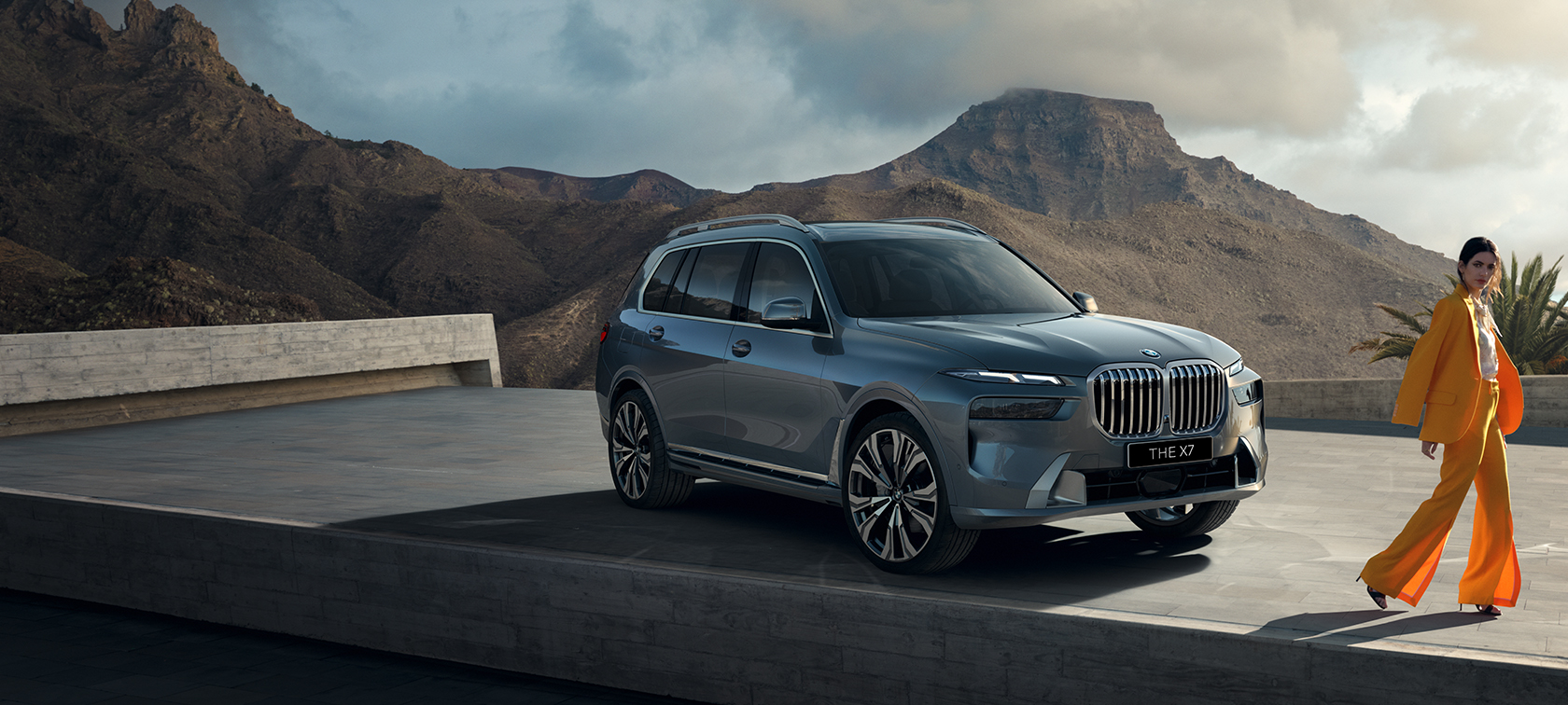 The new BMW X7 G07 LCI 7/8 Front view driving Sparkling Copper Grey metallic