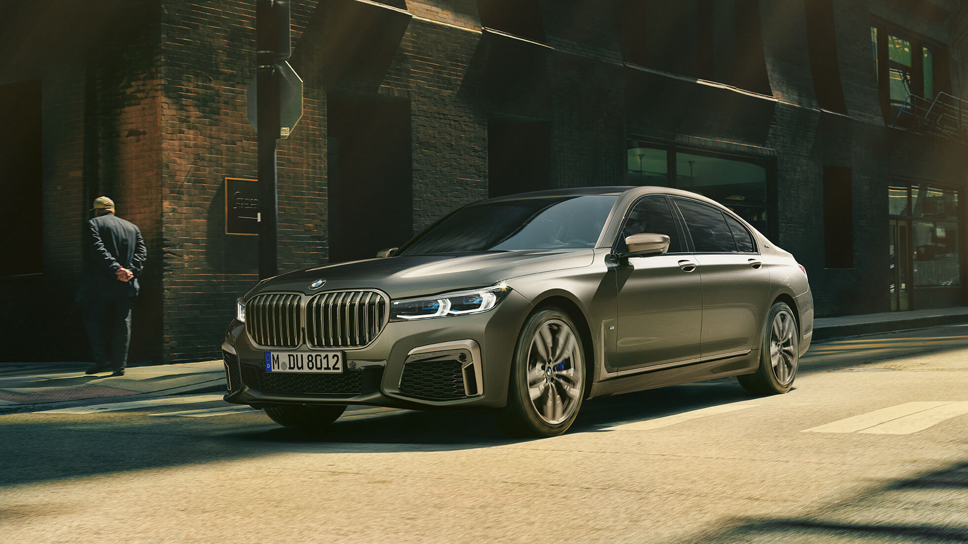 BMW M760Li xDrive in urban setting BMW M760Li xDrive in lateral front view driving on street in urban setting