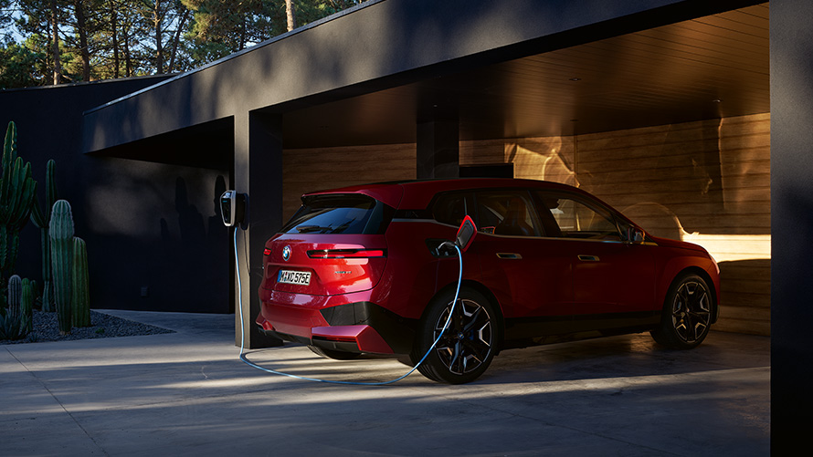 BMW iX i20 electric SUV BMW iX xDrive40 charging BMW iX i20 2021 electric SUV BMW iX xDrive40 Aventurin Red charging with a BMW Wallbox charging