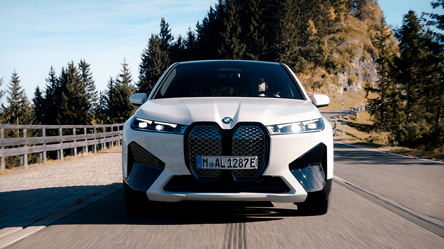 BMW iX i20 2021 electric SUV BMW iX xDrive40 Aventurin Red driving on a street performance
